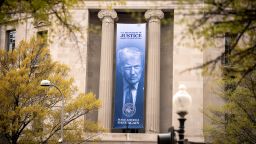 An image of President Donald Trump hangs from the Justice Department in Washington, DC, on April 3, 2026.
