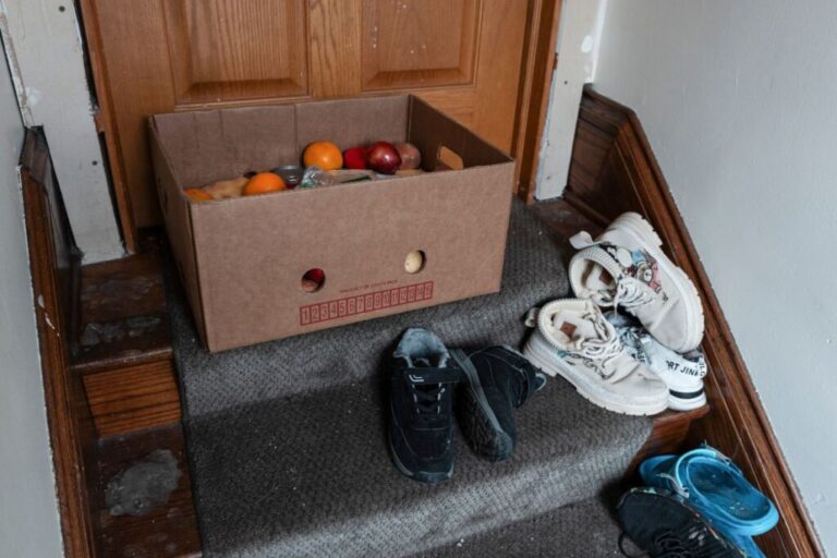 Food is left at an apartment door by Sergio Amezcua, a pastor at Dios Habla Hoy, on January 16.  Minneapolis residents have joined a church-run effort to deliver donated groceries to immigrant families who fear leaving their homes.