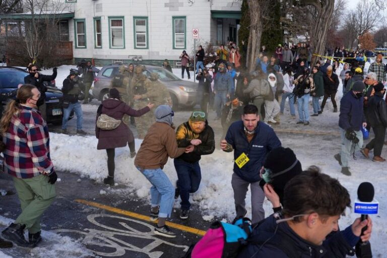 Members of the community and the media take cover as Border Patrol agents use chemical irritants to disperse a crowd, after Good was shot on January 7.