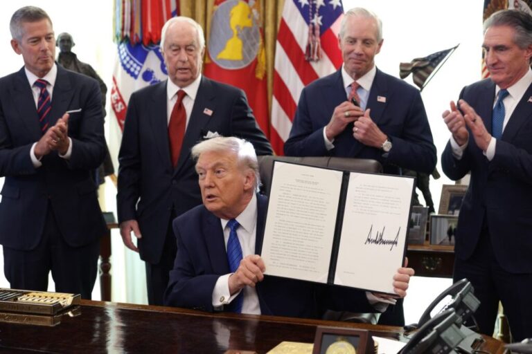President Donald Trump holds up a signed executive order bringing an IndyCar race to the District of Columbia, alongside Secretary of Transportation Sean Duffy, Penske Corporation Chair Roger Penske, Penske Corporation President Bud Denker, and Interior Secretary Doug Burgum, in the Oval Office of the White House on January 30.