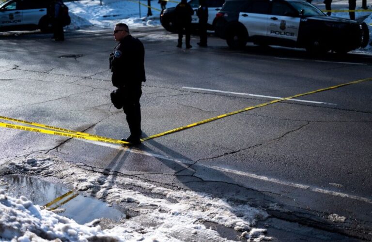 A Minneapolis Police officer holds a perimeter at the scene where Good was killed.