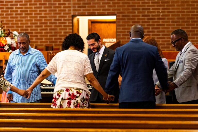 El-Sayed holds hands with church-goers during a closing prayer at New Bethel Missionary Baptist Church.