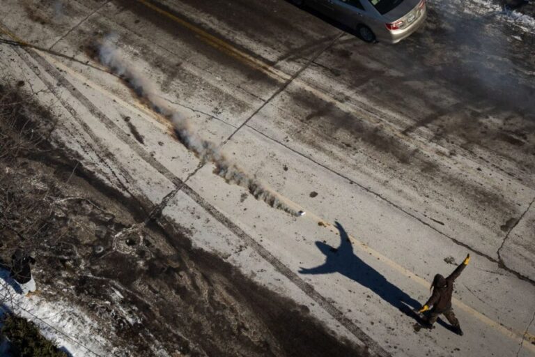 A person walks toward a tear gas canister in Minneapolis on January 24.