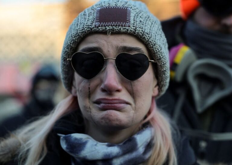 A woman cries at the makeshift memorial for Pretti on January 24. The Department of Homeland Security said Pretti had a handgun and “<a href=