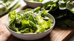 Torn romaine lettuce in a bowl on the kitchen table.