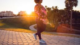 Curvy young black woman walking, jogging and running in the city public park