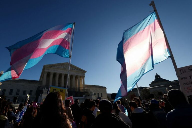 Demonstrators carry transgender flags outside the US Supreme Court, on the day justices are expected to hear oral arguments in two cases concerning efforts to enforce Republican-backed state laws banning transgender athletes from female sports teams at public schools, in Washington, DC, on January 13, 2026.