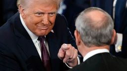 President Donald Trump points to Supreme Court Chief Justice John Roberts after being sworn in, inside the US Capitol Rotunda on January 20, 2025.