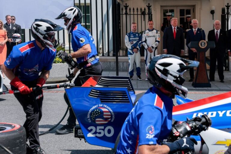 Grand Prix crew members work while President Donald Trump, IndyCar series owner Roger Penske, Freedom 250 Grand Prix Chair Bud Denker, and IndyCar series drivers Alex Palou and Felix Rosenqvist look on during a Freedom 250 Grand Prix Showcase at the White House on July 13.