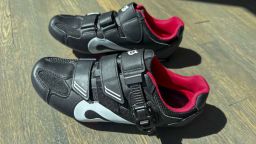 A pair of Peloton cycling shoes sitting on the ground.