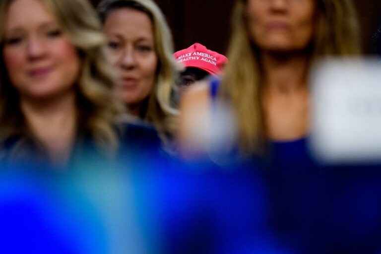 A woman wears a red hat reading