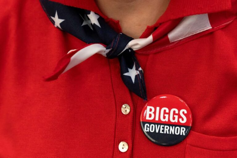 A woman sports a campaign button that reads “Biggs Governor” during a rally in support Rep. Andy Biggs in Gilbert, Arizona, July 17.