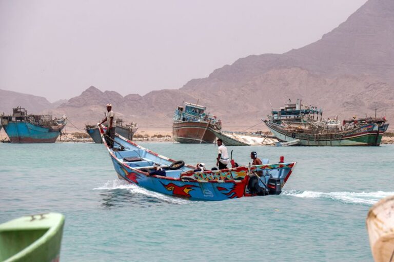 People sit in a fishing boat sailing the Bab el-Mandeb Strait off of Yemen's southern Taiz province on July 25.