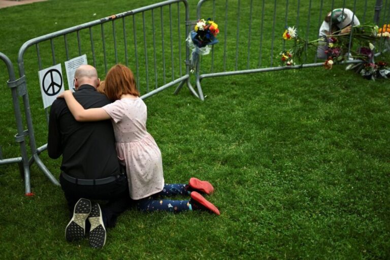 A man embraces his children at a memorial at the scene of an attack in Boulder, Colorado, on demonstrators showing support for Israeli hostages in Gaza on June 2, 2025.