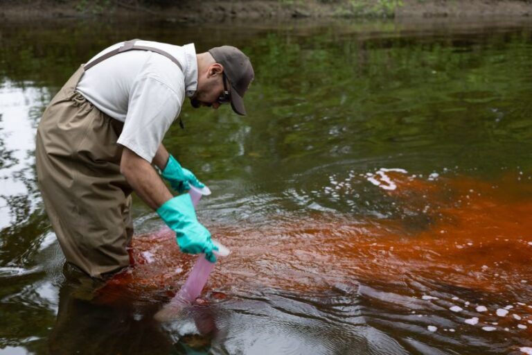 A worker treats water with lampricide, targeting sea lamprey larvae.
