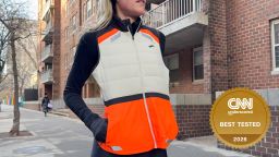 Woman wearing orange and white running vest on the street