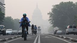 A cyclist rides under a blanket of haze partially obscuring the US Capitol in Washington, DC, on June 8, 2023. Smoke from Canadian wildfires have shrouded the US East Coast in a record-breaking smog, forcing cities to issue air pollution warnings and thousands of Canadians to evacuate their homes. The devastating fires have displaced more than 20,000 people and scorched about 3.8 million hectares (9,390,005 acres) of land. Prime Minister Justin Trudeau described this wildfire season as the country's worst ever. (Photo by Mandel NGAN / AFP) (Photo by MANDEL NGAN/AFP via Getty Images)