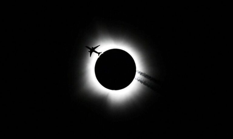 An airplane passes by as the total solar eclipse is seen from Bloomington, Indiana, on Monday, April 8.