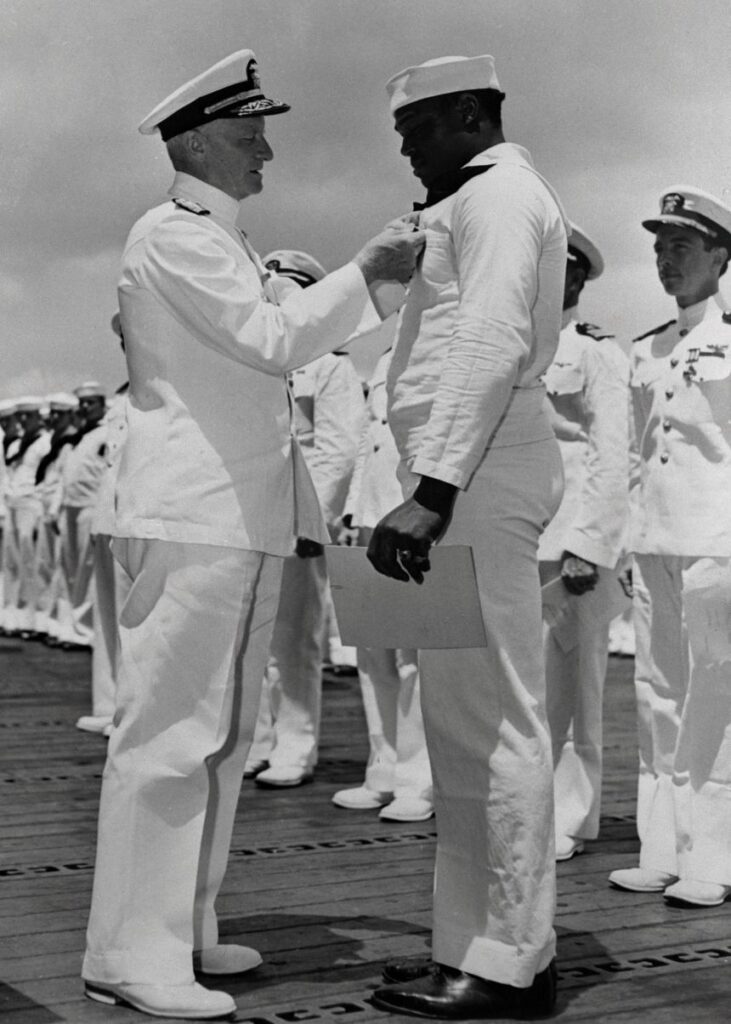 Admiral Chester W. Nimitz pins the Navy Cross on Doris Miller, in a ceremony aboard a warship at Pearl Harbor.