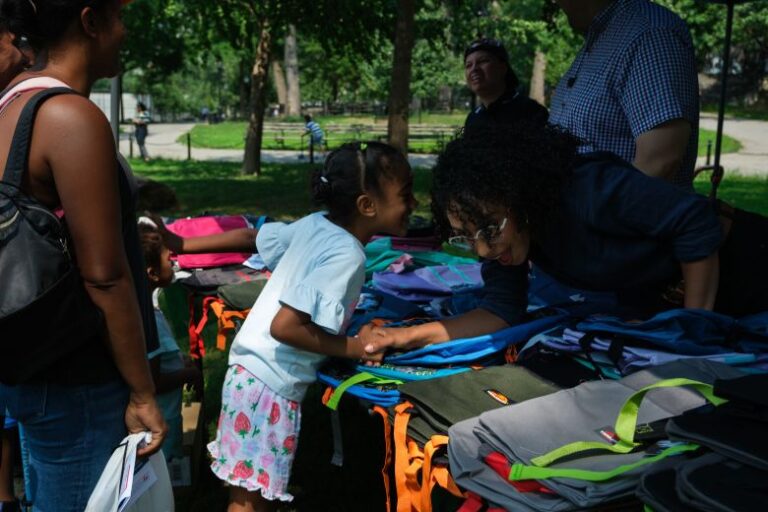 Darializa Avila Chevalier meets constituents while distributing backpacks with State Sen. Gustavo Rivera at St. James Park, in the Bronx borough of New York, on Thursday.
