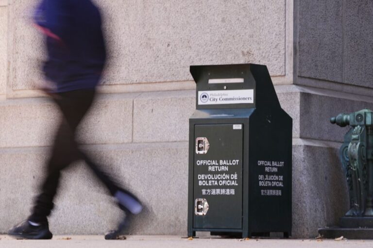 A person walks past a ballot return box for mail-in ballots outside City Hall in Philadelphia on October 27, 2025.