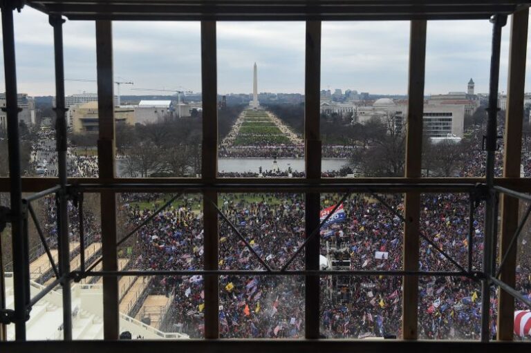 Supporters of US President Donald Trump are seen from behind scaffolding as they riot outside the US Capitol's Rotunda on January 6, 2021, in Washington, DC. Trump is seeking funds to compensate — among others — supporters convicted after the January 6, 2021, Capitol riot.