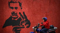 A motorcyclist rides past a mural of ousted Venezuela's President Nicolas Maduro flashing the V sign, in Caracas, on May 14, 2026. (Photo by Federico PARRA / AFP via Getty Images)