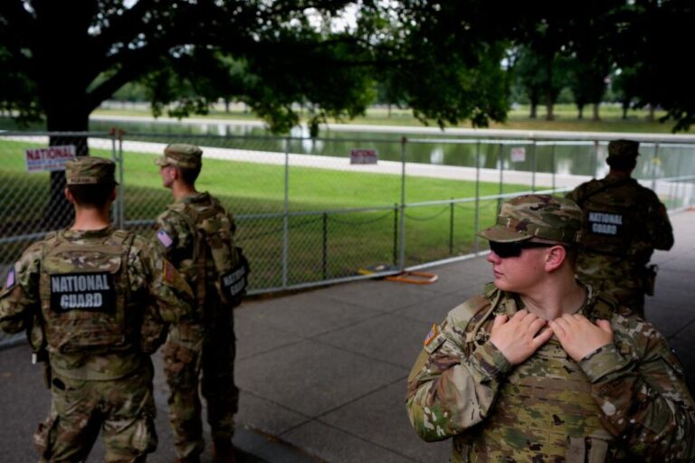 Members of the National Guard stand in the shade near the Reflecting Pool on the National Mall on July 9, in Washington, DC.