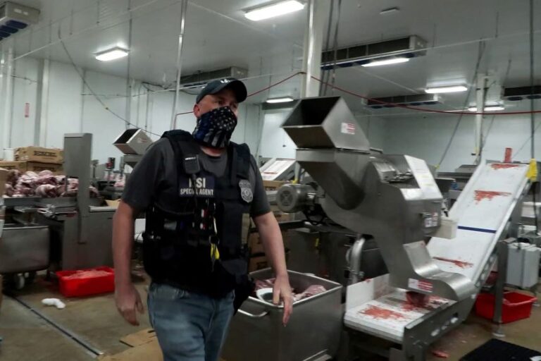 An agent passes meat being prepared during a raid by US Immigration and Customs Enforcement at a Glenn Valley Foods meat production plant in Omaha, Nebraska, on June 10, 2025 in a still image taken from a video.