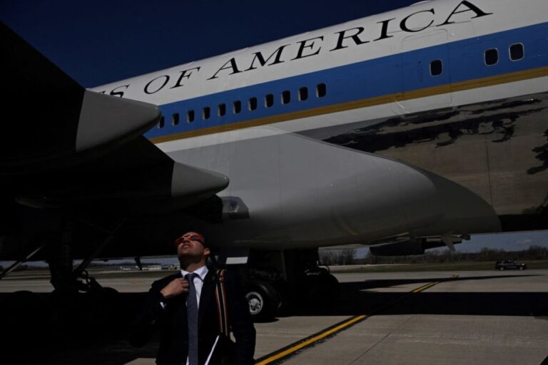 A White House staffer looks up at the eclipse as US President Joe Biden arrives at the Dane County Regional Airport in Madison, Wisconsin.
