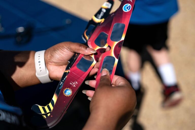Volunteers hand out eclipse glasses to view the partial solar eclipse in April 2024 in Washington, DC.