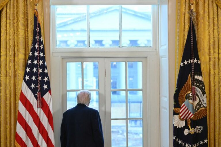 US President Donald Trump looks through a window to observe construction work on his new ballroom prior to a meeting with US oil company executives in the East Room of the White House in Washington, DC, on January 9.