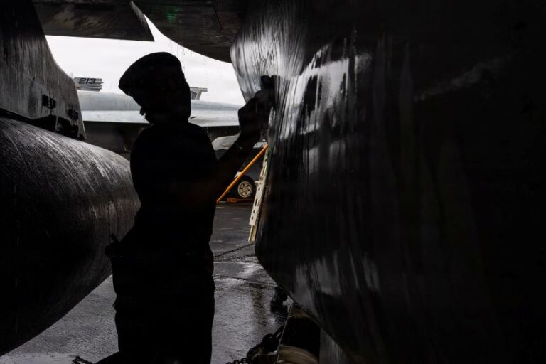 A US sailor, assigned to Electronic Attack Squadron 133, scrubs an EA-18G Growler on the flight deck of the Nimitz-class aircraft carrier USS Abraham Lincoln during the ongoing conflict with Iran August 9, 2026.