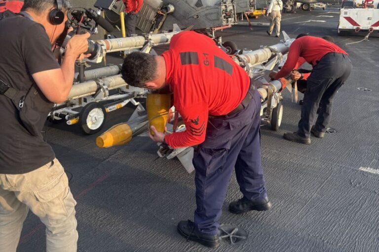 A sailor fits a cap onto artillery on the USS Lincoln.