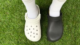 A photo showing somebody wearing a black pair of VKTRY recovery clogs on the left and a white pair of Crocs on the right.