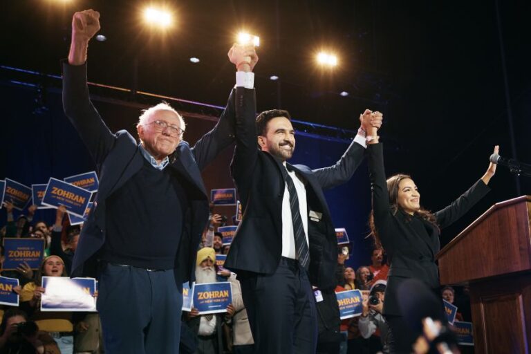Zohran Mamdani, center, celebrates with Sen. Bernie Sanders, left, and Rep. Alexandria Ocasio-Cortez during an election rally on October 26, 2025, in Queens.