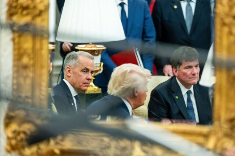 Prime Minister Mark Carney of Canada is reflected in a mirror as he meets with President Donald Trump in the Oval Office of the White House in Washington, DC, in May 2025.