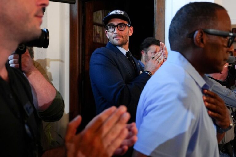 Streamer Hasan Piker, center, applauds as Abdul El-Sayed speaks during a campaign rally at a coffee shop on Monday.