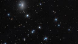 The low-surface-brightness galaxy CDG-2, shown in this image from the NASA/ESA Hubble Space Telescope, is dominated by dark matter and contains only a sparse scattering of stars. This galaxy is nearly invisible, but by using advanced statistical techniques, scientists identified it by searching for tight groupings of stars called globular clusters at the centre of this image. The Hubble observations include those from programme 15235 (W. Harris). [Image description: A field of space with a dozen white foreground stars and a number of small, yellow background galaxies.]