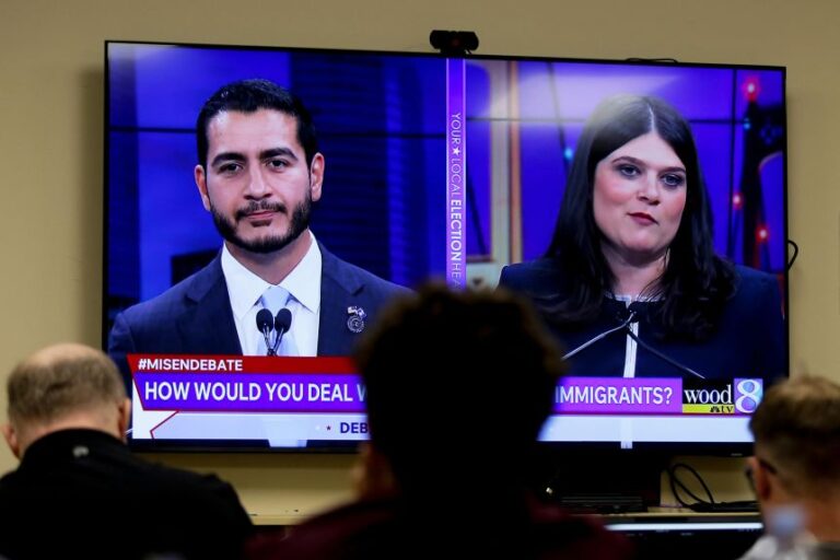 Michigan US Senate candidates Abdul El-Sayed, left, and Rep. Haley Stevens, are displayed on a television during a debate inside the spin room at WoodTV studios in Grand Rapids, Michigan, on July 7, 2026.