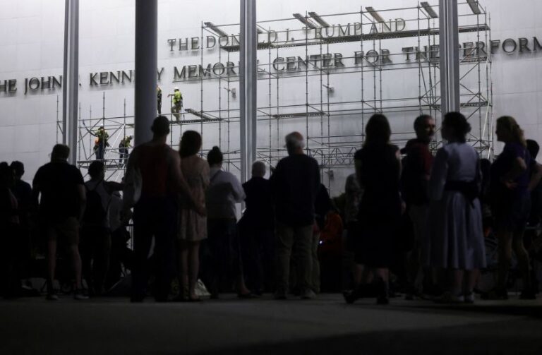 People look at workers as they set up scaffolding to remove lettering from the facade of the John F. Kennedy Memorial Center for the Performing Arts, following a federal judge’s order to remove President Donald Trump's name from the institution, in Washington, DC, on June 12.