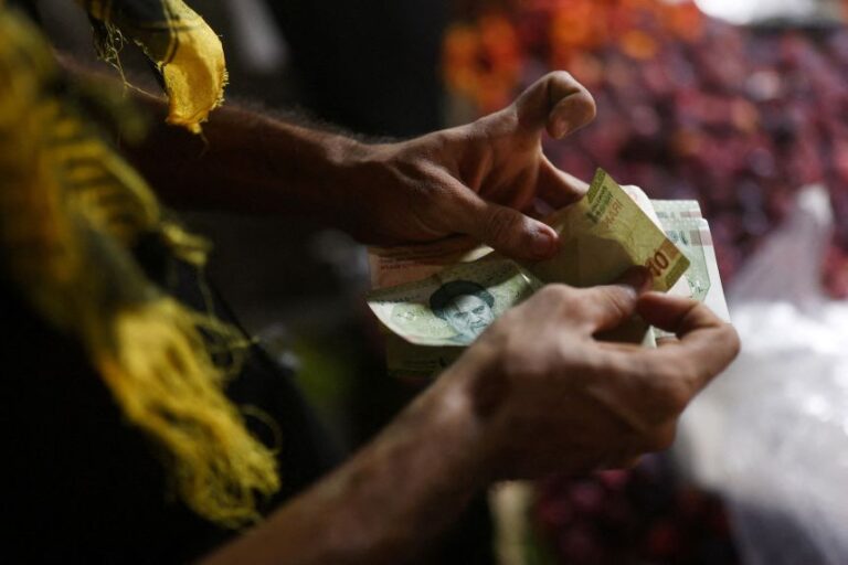 A salesman counts Iranian Rials at a local market in Bandar Abbas, Iran, August 25, 2026.