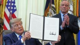 President Donald Trump holds a signed executive order about vaccines as Health and Human Services Secretary Robert F. Kennedy Jr. looks on, Monday, Aug. 10, 2026, in the Oval Office of the White House in Washington.