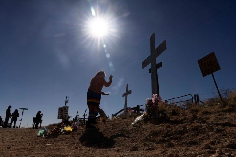Elisa Standridge, of Oklahoma City, cleanses a memorial at the entrance to Zorro Ranch, a property formerly owned by Jeffrey Epstein, on International Women’s Day near Stanley, New Mexico, on March 8.