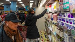 People rush to get groceries after waiting in line for the opening of a Trader Joe's grocery store on February 22, 2026 in New York City.