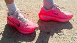 Bright pink Nike shoes on pavement.
