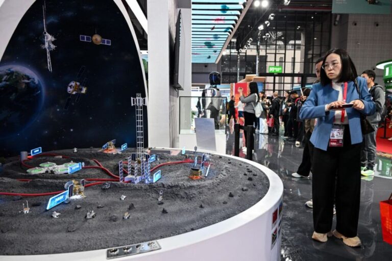 Visitors look at a scale model of the International Lunar Research Station at China's pavilion during the 8th International Import Expo in Shanghai in 2025.