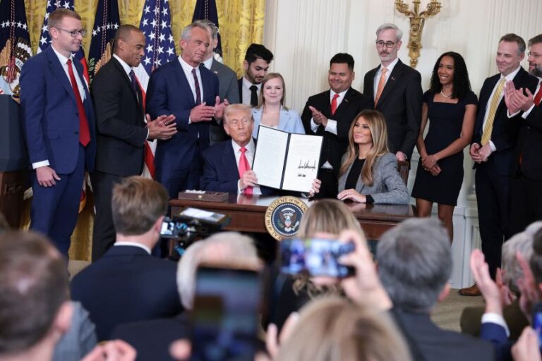 First lady Melania Trump sits next to President Donald Trump as he holds a signed executive order regarding foster care, in the East Room of the White House on November 13, 2025.