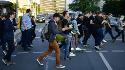 Young players walk through the city centre of Hanover while holding their smartphones and playing