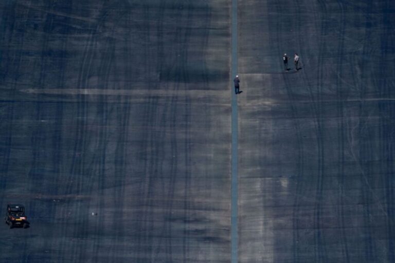 People are seen walking on the basin floor of the Lincoln Memorial Reflecting Pool on the National Mall in Washington, DC, on July 30.